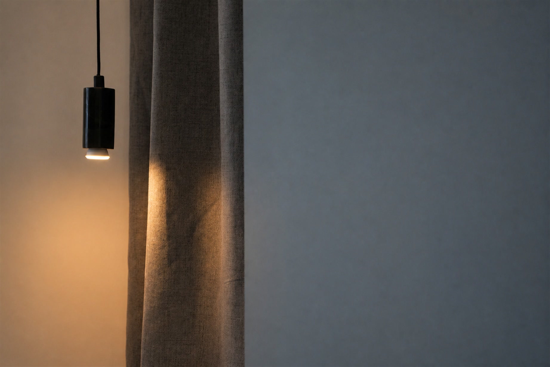 Lampada sospesa accanto alla tenda chiara