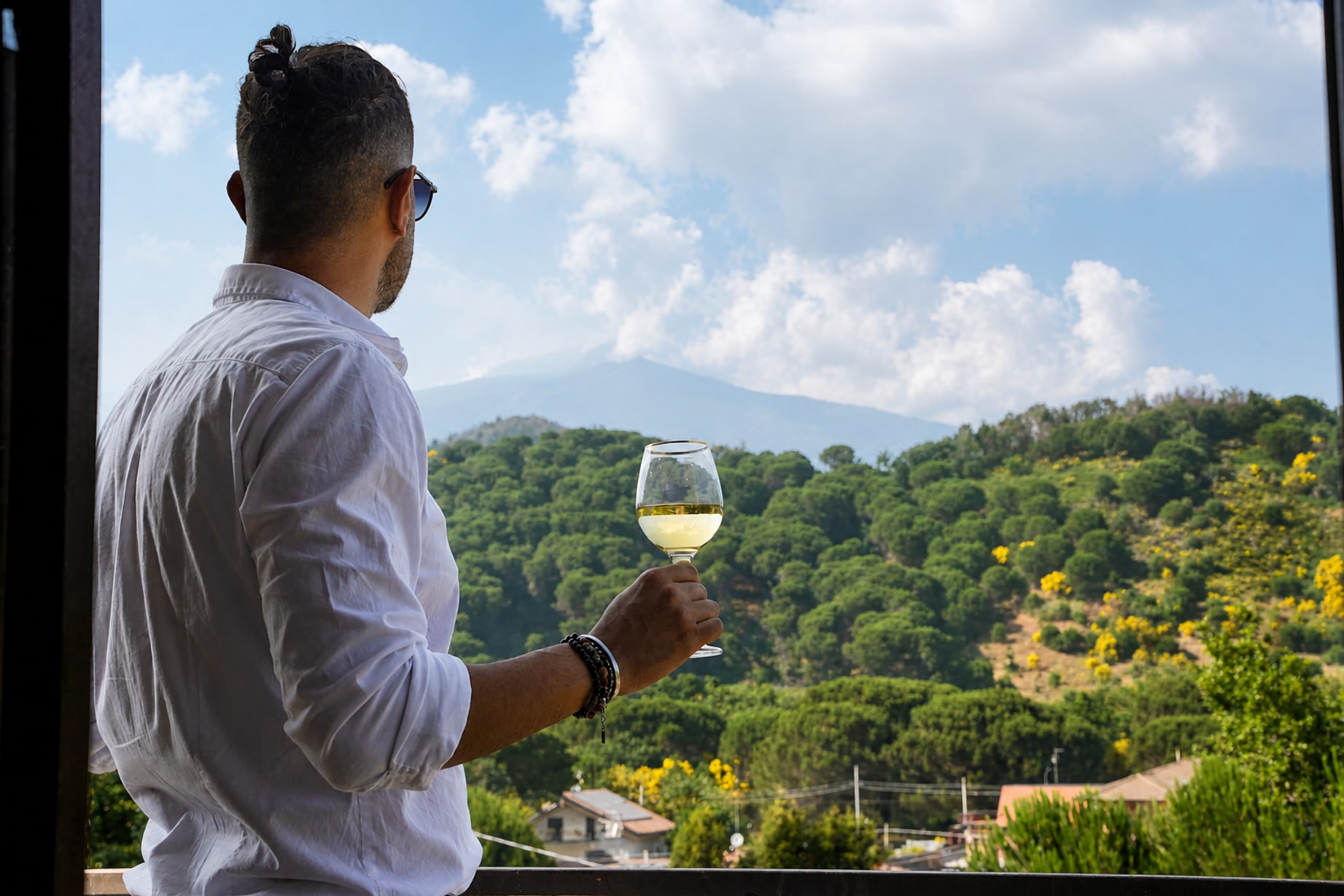 Un calice di vino bianco sulla terrazza, davanti alle colline verdi