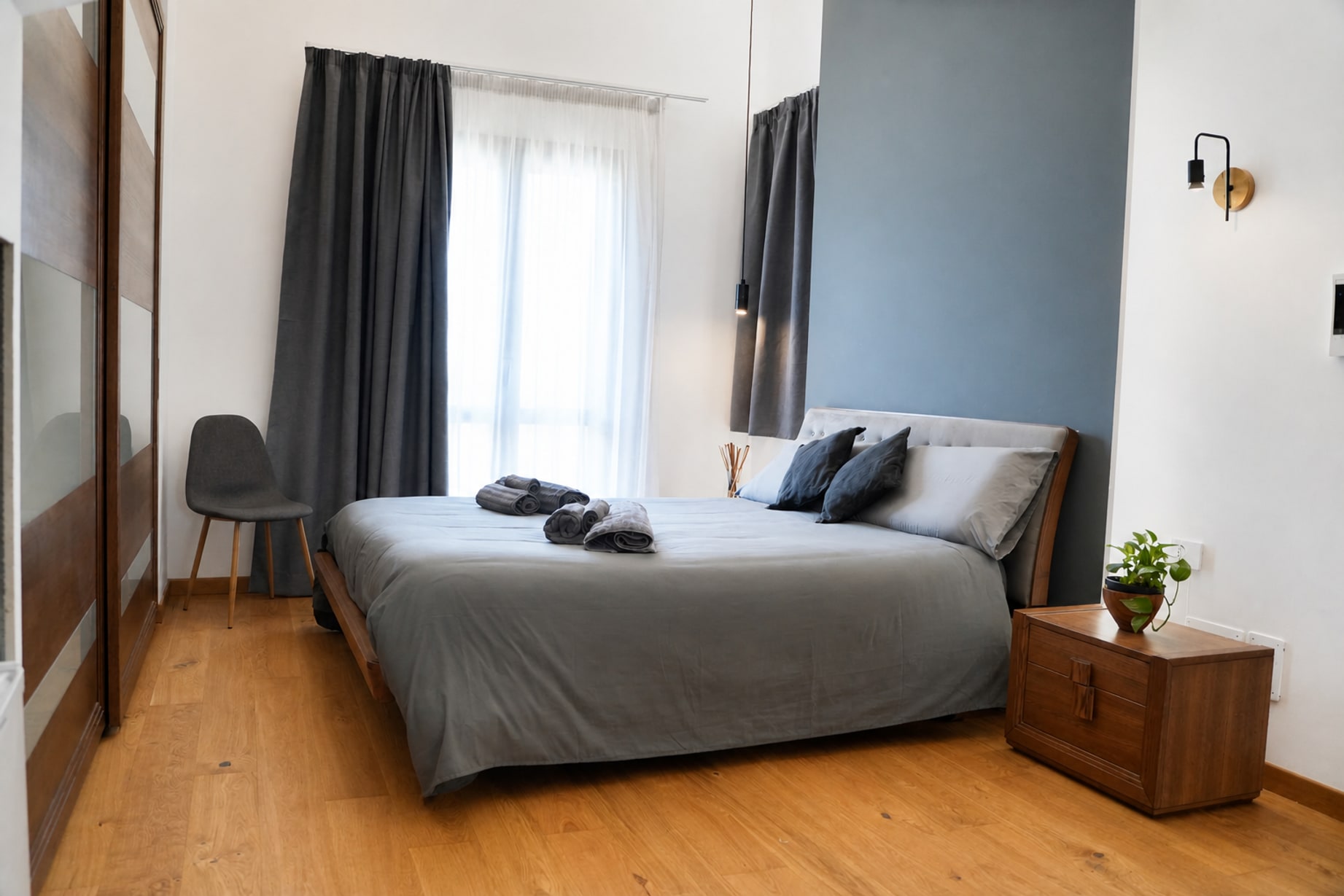 La camera vista dall'ingresso: letto, sedia e luce dalla finestra