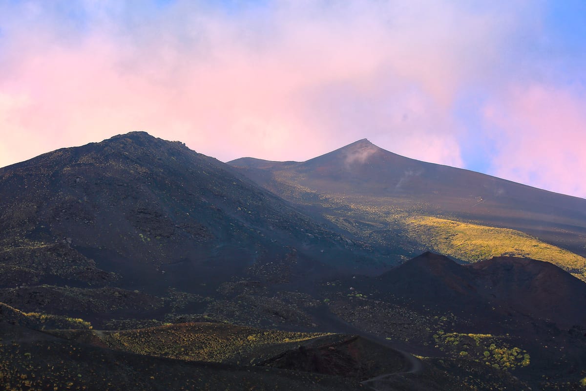I coni del vulcano contro il cielo rosa del tramonto