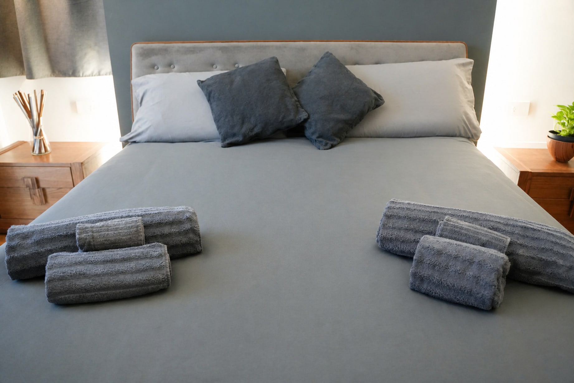 Letto rifatto di fresco con cuscini e asciugamani arrotolati